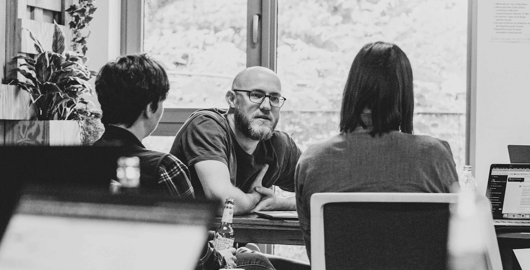 Thre team and product coaches sitting together discussing a topic